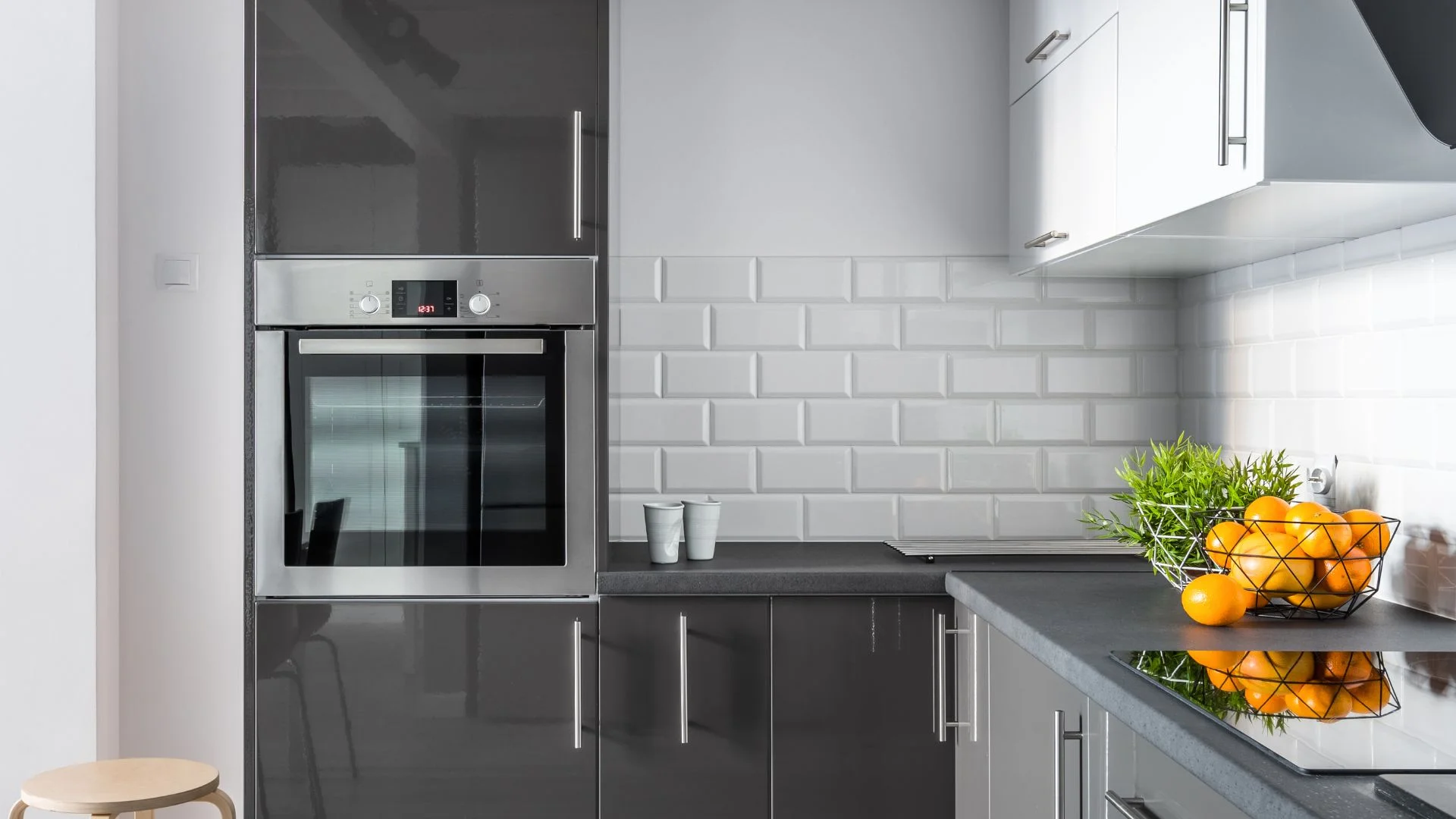 Cocina reformada con muebles claros y península para desayunar en una vivienda adosada