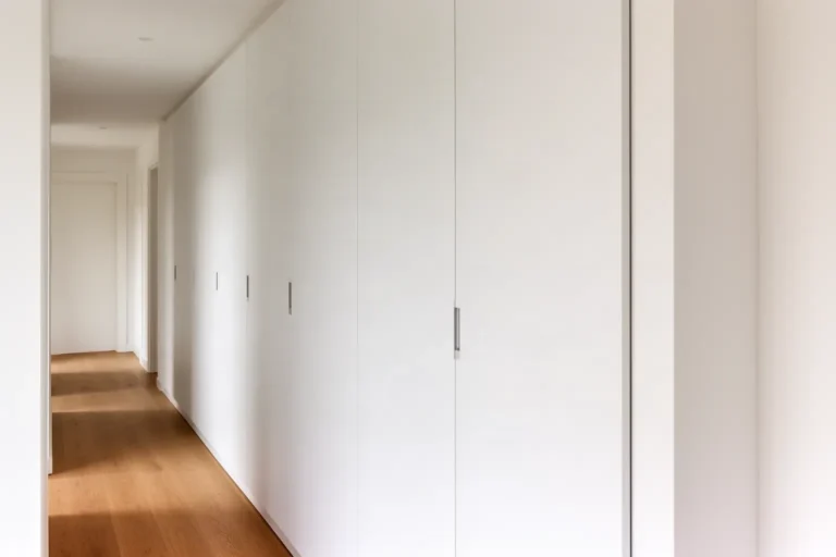 Armario empotrado de puertas lisas integrado a lo largo de un pasillo