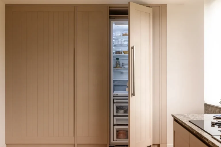 Frigorífico integrado en una columna de cocina con puerta panelada