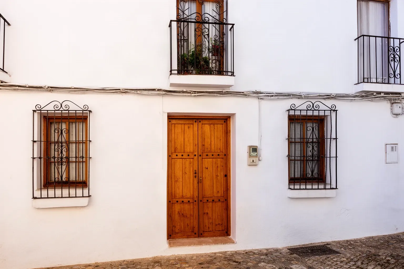 Casa de pueblo encalada en Umbrete con la puerta de madera recién restaurada