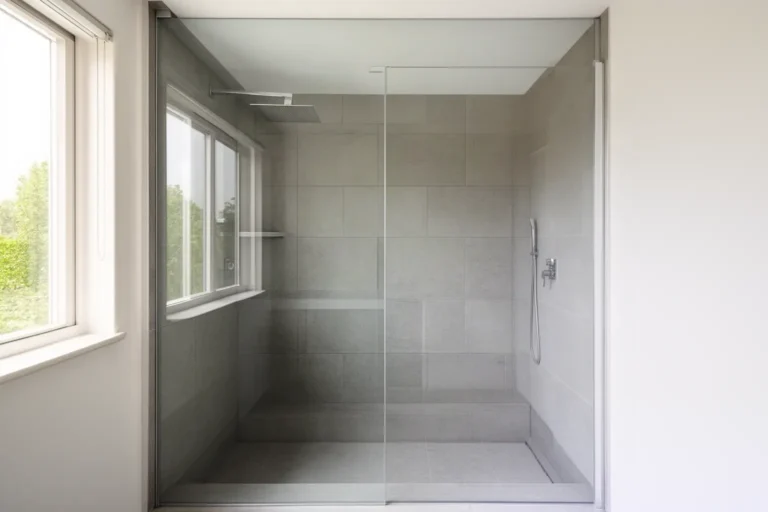 Ducha de diseño con mampara de cristal instalada en el hueco de una antigua bañera